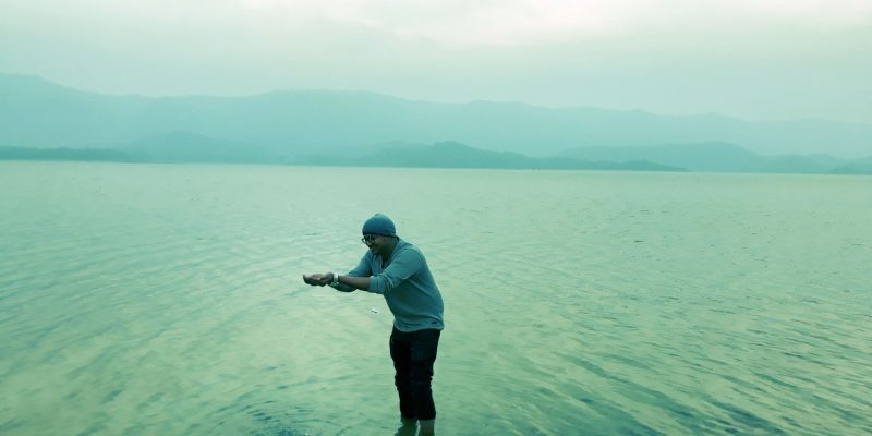 Young tourist in hands holding water in river – free photo
