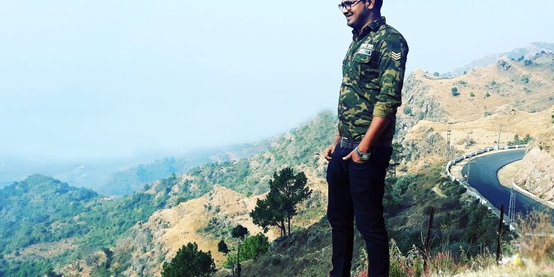 Young happy tourist man looking at beautiful landscape with road – free photo