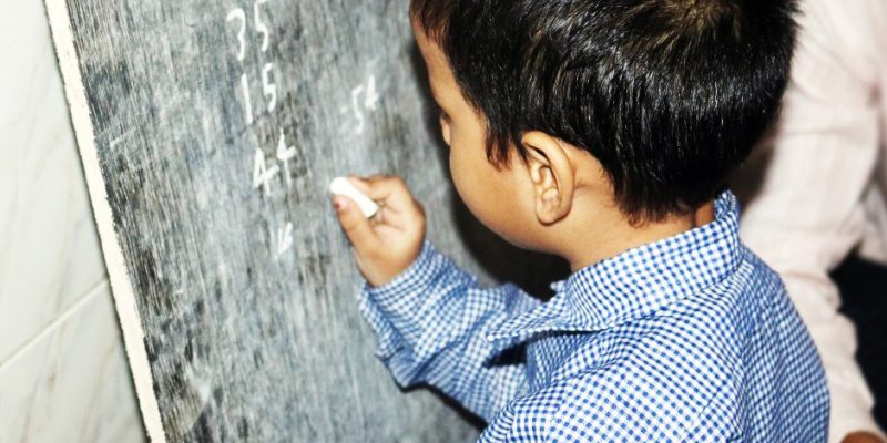 Boy child writing on school board – free photo